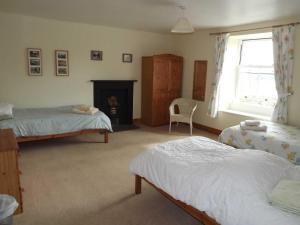 a bedroom with two beds and a fireplace at Skellgill House in Askrigg