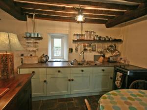 a kitchen with blue cabinets and a window at Penroc in Pentre-briwnant