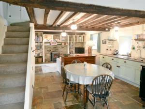 a kitchen and dining room with a table and stairs at Penroc in Pentre-briwnant
