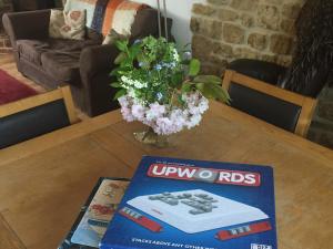 a table with a book and flowers on top of it at Feltham's Cottage - Uk42324 in Horsington