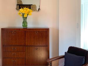 a vase of yellow flowers sitting on top of a dresser at Feltham's Cottage - Uk42324 in Horsington