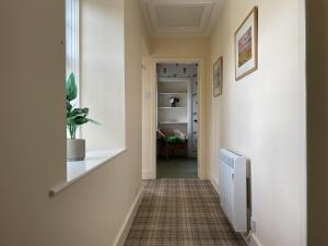 a hallway with a radiator and a plant on a wall at Birch Cottage - Uk38992 in Dalcross