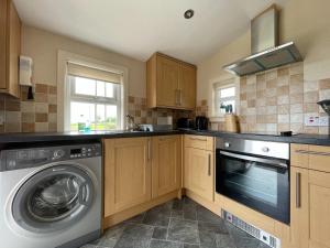 a kitchen with a washer and a dishwasher at Birch Cottage - Uk38992 in Dalcross