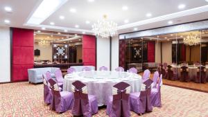 a banquet hall with purple tables and chairs at Shunde Grand View Hotel in Shunde
