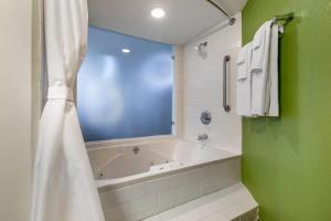 a bathroom with a tub and a green wall at Sleep Inn Allentown-Fogelsville in Allentown +32 photos