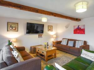 a living room with two couches and a tv at Lower House Barn in Staunton on Wye