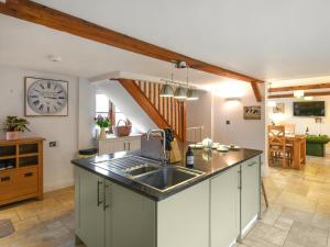 a kitchen with a sink and a clock on the wall at Lower House Barn in Staunton on Wye +11 photos