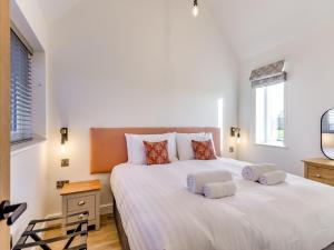 a bedroom with a large white bed with two pillows at The Piggery - Uk37348 in Hockerton