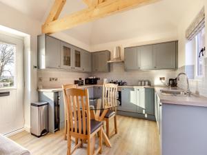a kitchen with green cabinets and a table and chairs at The Piggery - Uk37348 in Hockerton