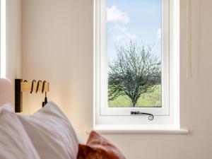 a window with a tree in a bedroom at The Piggery - Uk37348 in Hockerton