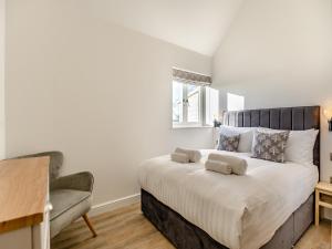 a bedroom with a large bed and a chair at The Piggery - Uk37348 in Hockerton