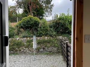 an open door to a yard with a fence at Sanna in Ardentinny