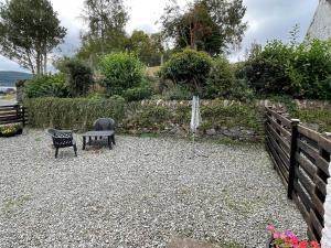 a garden with a bench and a water fountain at Sanna in Ardentinny +3 photos