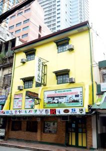 a yellow building on a city street with tall buildings at duck inn manila in Manila