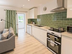 a kitchen with a couch and a stove top oven at Foxwhelp in Ledbury