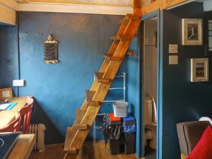a wooden staircase in a room with a blue wall at Y Smithy - Uk49022 in Llanybyther