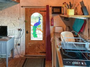 a kitchen with a door with a peacock window at Y Smithy - Uk49022 in Llanybyther