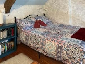 a bedroom with a bed with red shoes on it at Y Smithy - Uk49022 in Llanybyther