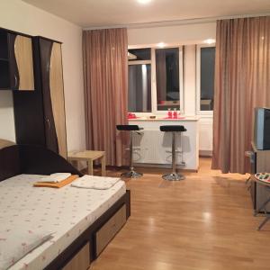 1 dormitorio con 1 cama, 1 mesa y 2 taburetes en Alina Accommodation, en Galaţi