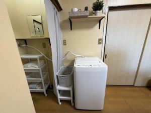 a laundry room with a washing machine and a door at Omuta Cozy Stay in Ōmuta