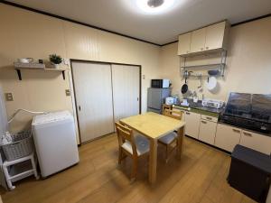 a small kitchen with a table and a refrigerator at Omuta Cozy Stay in Ōmuta