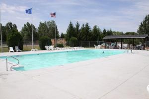 a large swimming pool with blue water and two flags at Lakeland RV Campground Loft Cabin 1 in Edgerton