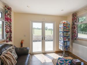 a living room with a couch and a sliding glass door at Willow - Glamping Pod - Uk49947 in Oswestry +11 photos