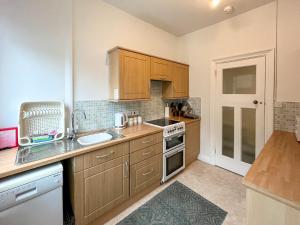 a small kitchen with wooden cabinets and a sink at Seawinds - Uk50857 in Colwyn Bay