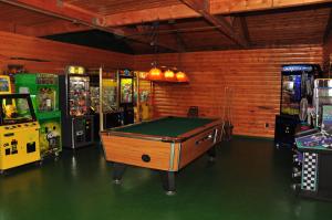 a room with a pool table and several arcade machines at Arrowhead Camping Resort Loft Cabin 20 in Douglas Center