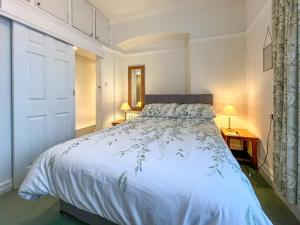 a bedroom with a bed with a white comforter at Seawinds - Uk50857 in Colwyn Bay +6 photos