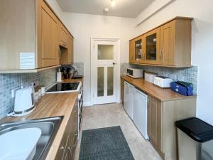 a kitchen with wooden cabinets and a sink at Seawinds - Uk50857 in Colwyn Bay