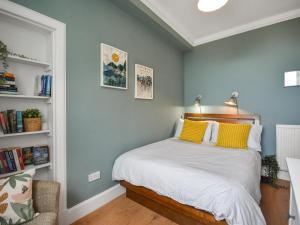 a bedroom with a bed with yellow pillows on it at The Leveret in Aberlady