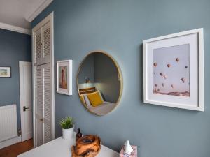 a blue room with a mirror and a table at The Leveret in Aberlady +7 photos