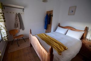 a bedroom with a bed with a yellow blanket on it at Golan - Ukc4677 in Clynnog-fawr