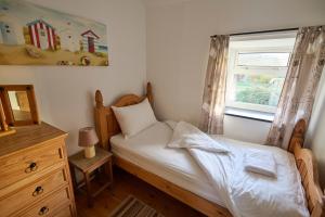 a small bedroom with a bed and a window at Golan - Ukc4677 in Clynnog-fawr +5 photos