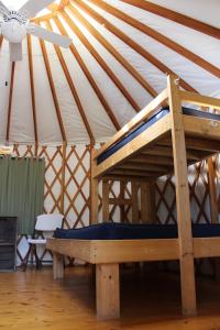 a wooden bed in a yurt with a ceiling at Tranquil Timbers Yurt 3 in Sturgeon Bay