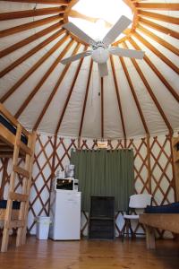 a ceiling fan in a yurt with a refrigerator at Tranquil Timbers Yurt 3 in Sturgeon Bay