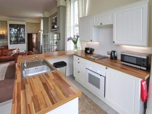 a kitchen with white cabinets and a sink at Stargazers - Uk3445 in Greenhaugh +7 photos