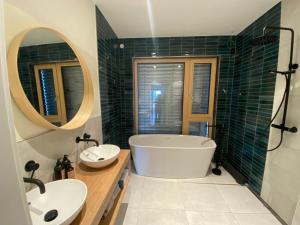 a bathroom with a tub and two sinks and a mirror at Eco-Chalet Matschiedl in Tratten +25 photos