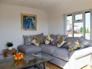 a living room with a couch and a glass table at Y Bwthyn At Tyddyn Obry in Llanfaelog