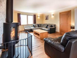 a living room with a couch and a fireplace at Beinn View House in Cononbridge