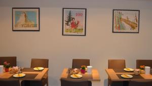 a dining room with tables and chairs and pictures on the wall at Central Hotel Post in Chur