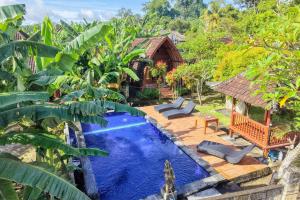 a pool in the middle of a yard with trees at The Tandjung Cottage in Nusa Penida
