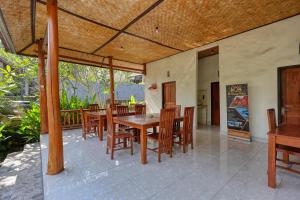a dining room with a table and chairs on a patio at The Tandjung Cottage in Nusa Penida