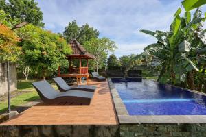 a backyard with a swimming pool and a gazebo at The Tandjung Cottage in Nusa Penida