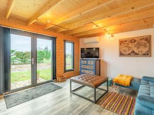 a living room with a blue couch and a television at Holly's Hidden Hideaway - Uk36783 in Sutton Valence