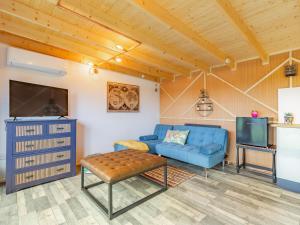 a living room with a blue couch and a tv at Holly's Hidden Hideaway - Uk36783 in Sutton Valence