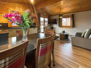 a kitchen and living room with a vase of flowers on a table at Lodge 5 - Uk51251 in Glasgow