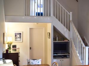 a living room with a staircase with a tv at Gushat Cottage in Strathtay +35 photos