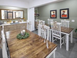 a kitchen and dining room with a wooden table and chairs at Sage Haven Guesthouse in Modimolle